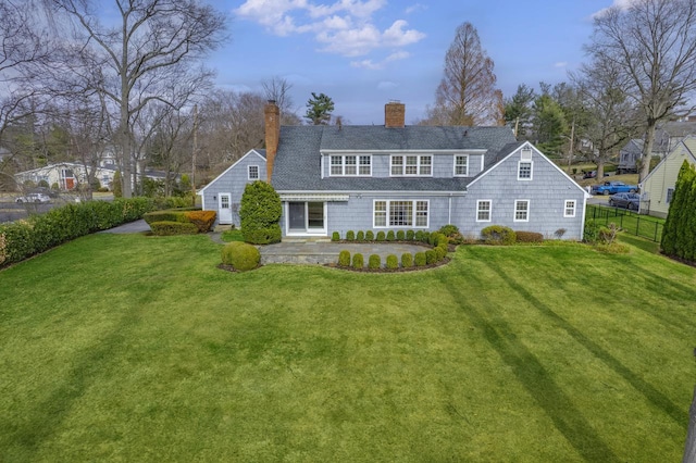 back of house with a yard, a chimney, a patio area, and fence