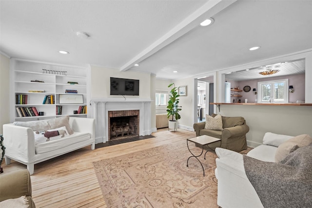 living area featuring a brick fireplace, light wood-style flooring, baseboards, and beamed ceiling