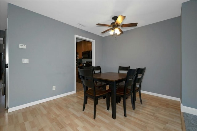 dining area with light wood-style floors, visible vents, ceiling fan, and baseboards