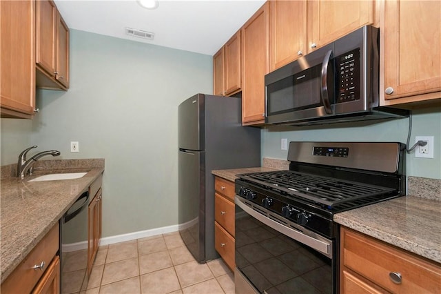 kitchen featuring baseboards, visible vents, appliances with stainless steel finishes, a sink, and light tile patterned flooring