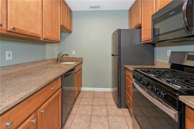 kitchen with black dishwasher, visible vents, a sink, light stone countertops, and stainless steel gas range