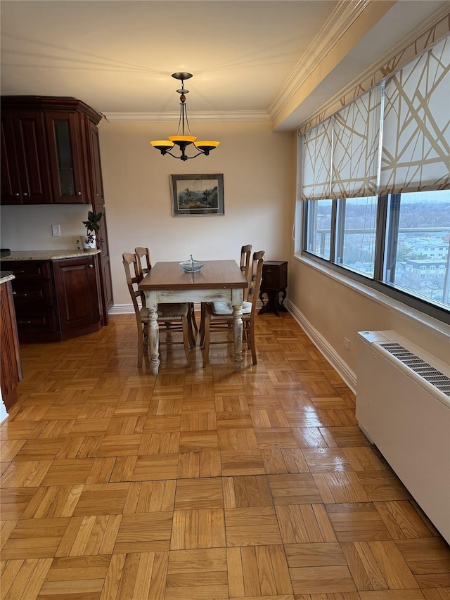 dining space featuring a notable chandelier, radiator heating unit, ornamental molding, and baseboards