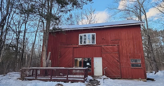 snow covered structure with an outbuilding and a barn