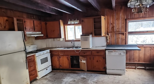 kitchen with white appliances, a sink, wood walls, under cabinet range hood, and beam ceiling