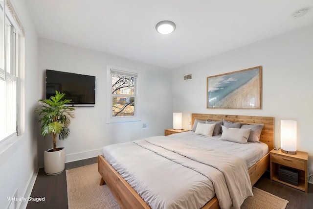 bedroom featuring visible vents, baseboards, and dark wood finished floors