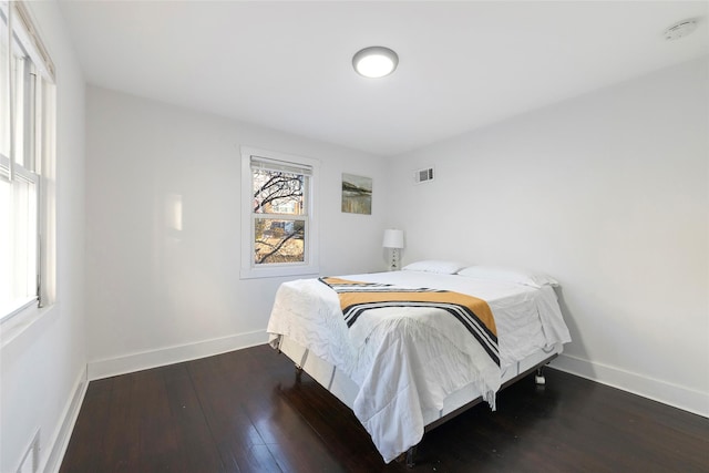 bedroom featuring dark wood-type flooring, visible vents, and baseboards