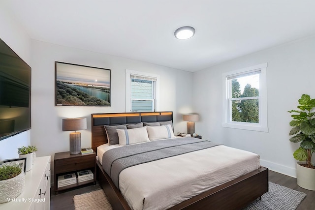 bedroom with baseboards and dark wood finished floors