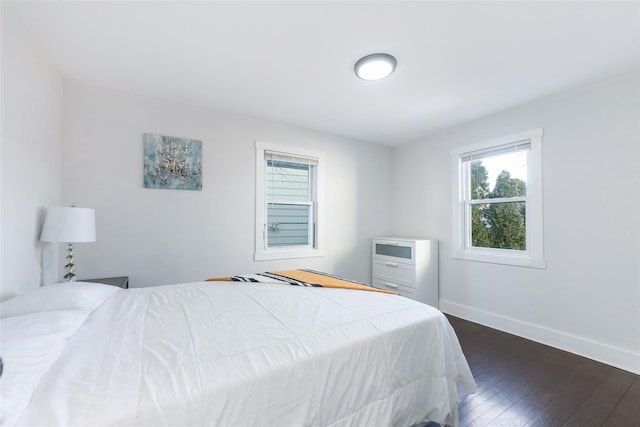 bedroom with baseboards and dark wood finished floors