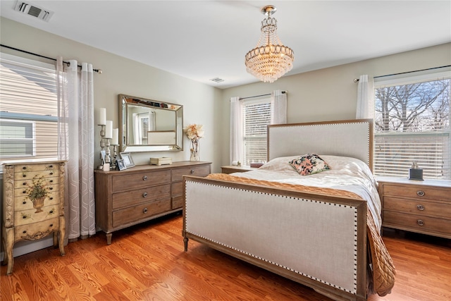 bedroom featuring light wood-type flooring, visible vents, and multiple windows