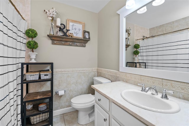 bathroom with toilet, tile patterned floors, curtained shower, vanity, and tile walls