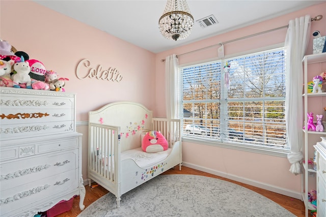 bedroom featuring baseboards, multiple windows, visible vents, and a chandelier