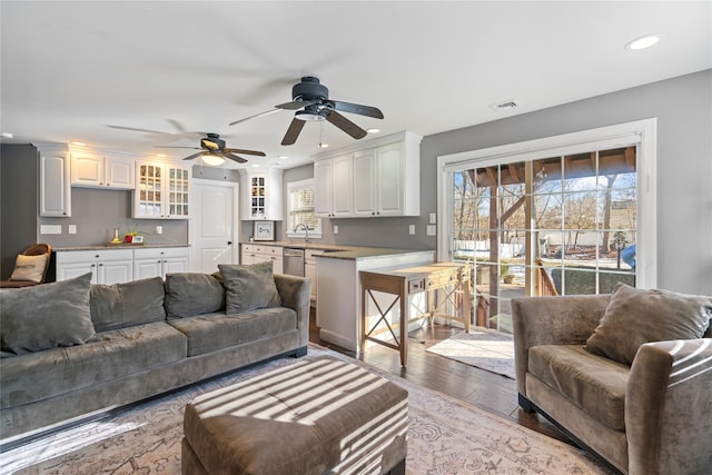 living room with wood finished floors, visible vents, and recessed lighting