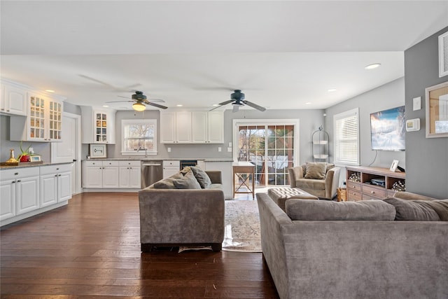 living area with plenty of natural light, dark wood finished floors, a ceiling fan, and recessed lighting