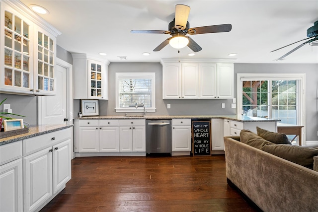 kitchen with dark wood finished floors, a ceiling fan, dishwasher, glass insert cabinets, and a sink