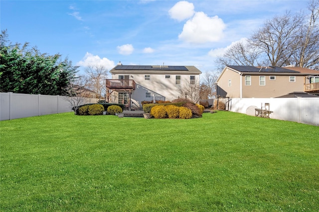 rear view of property with a fenced backyard and a yard