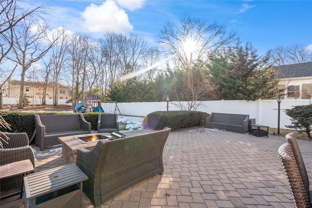 view of patio / terrace with a fenced backyard, a playground, and an outdoor living space with a fire pit