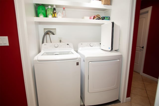 washroom featuring laundry area, tile patterned flooring, and separate washer and dryer