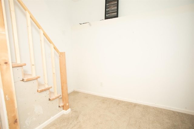 below grade area with carpet floors, stairway, and baseboards