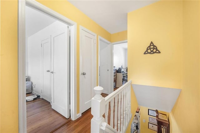 corridor featuring light wood-style floors and an upstairs landing