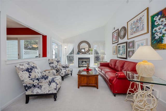 carpeted living area featuring lofted ceiling, a glass covered fireplace, and baseboards