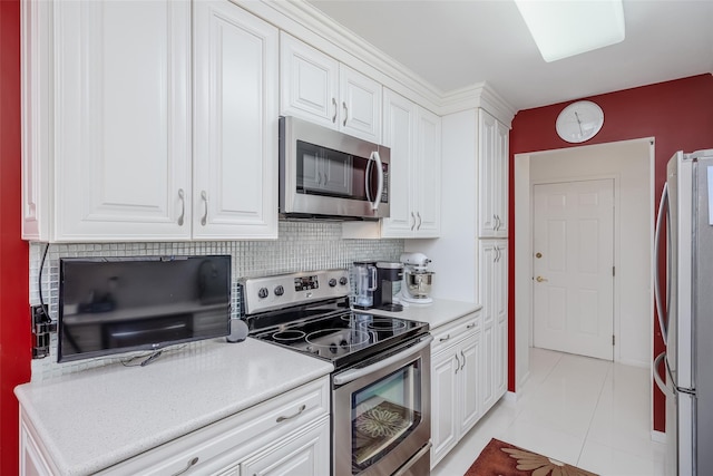 kitchen with stainless steel appliances, light countertops, and white cabinetry