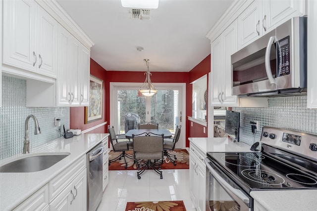 kitchen with a sink, stainless steel appliances, light countertops, and white cabinets