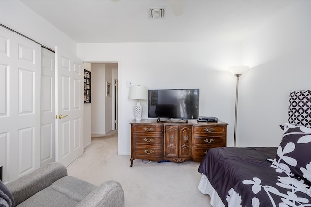 bedroom with light colored carpet, a closet, and visible vents