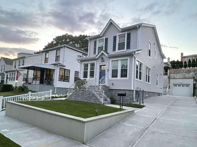 view of front of property featuring an outbuilding, concrete driveway, and a lawn