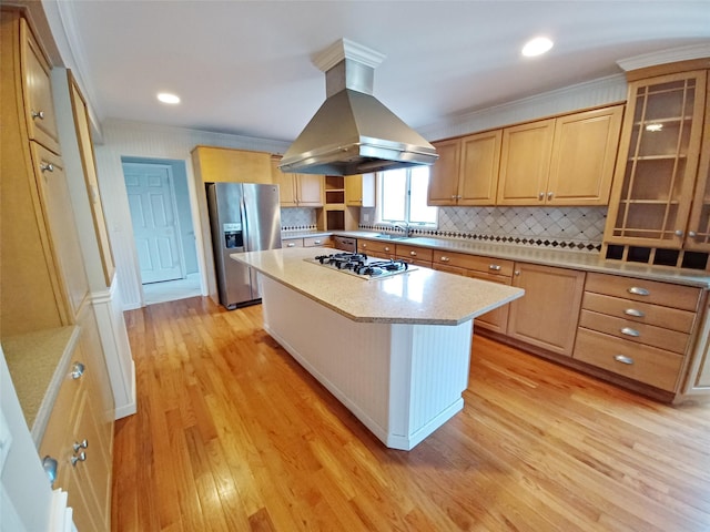 kitchen featuring glass insert cabinets, a center island, island exhaust hood, stainless steel appliances, and light countertops