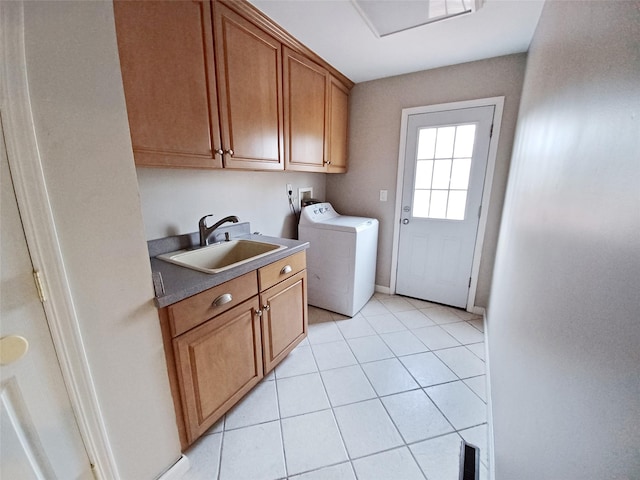 laundry area featuring light tile patterned floors, a sink, baseboards, cabinet space, and washer / dryer