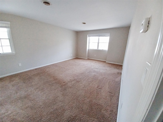 unfurnished room with baseboards and light colored carpet