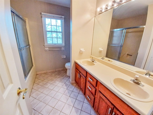 bathroom featuring combined bath / shower with glass door, a sink, and toilet