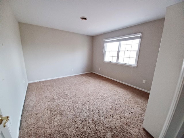 spare room with carpet and baseboards