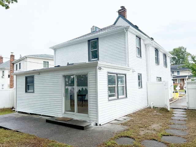 back of property with fence and a chimney