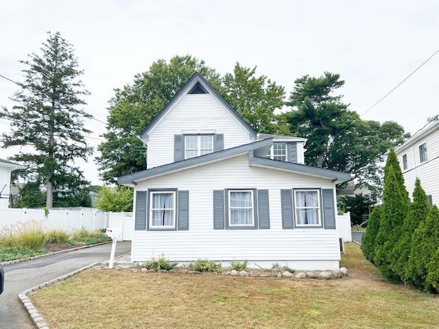 view of side of property with a yard, fence, and driveway