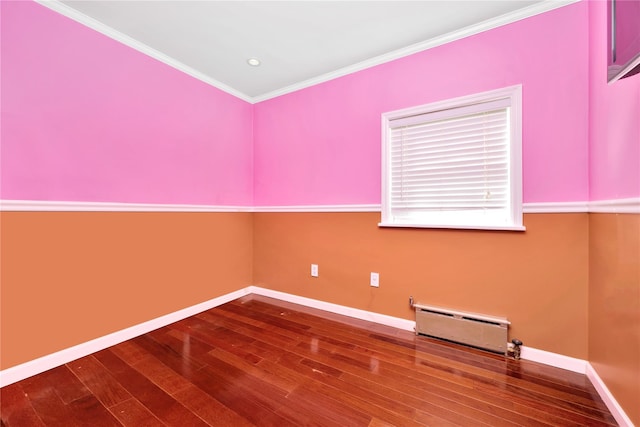 empty room featuring recessed lighting, a baseboard heating unit, wood finished floors, baseboards, and ornamental molding