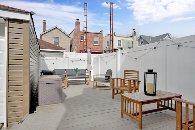 deck featuring a residential view, a fenced backyard, and an outdoor living space