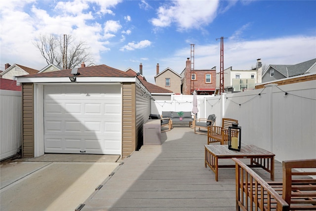 deck featuring a detached garage, a residential view, fence, and an outbuilding