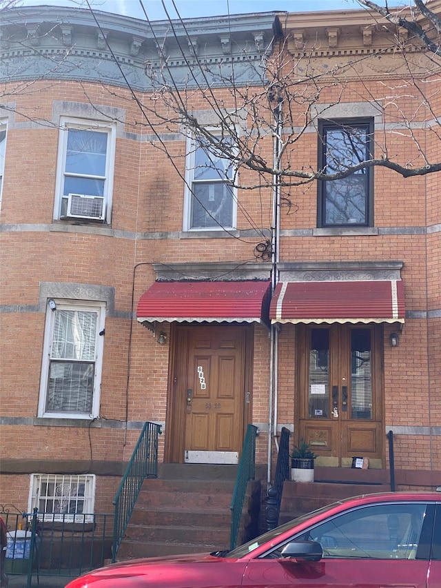 townhome / multi-family property with cooling unit, french doors, and brick siding