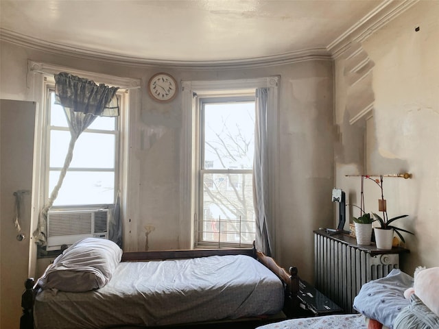 bedroom featuring ornamental molding, multiple windows, cooling unit, and radiator