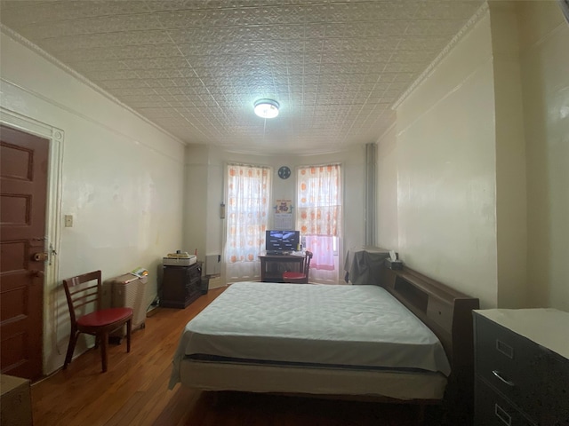 bedroom featuring crown molding and wood finished floors