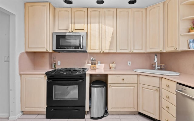 kitchen featuring open shelves, stainless steel appliances, light countertops, light brown cabinets, and a sink