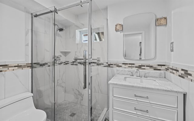 full bath featuring toilet, a marble finish shower, tile walls, and vanity