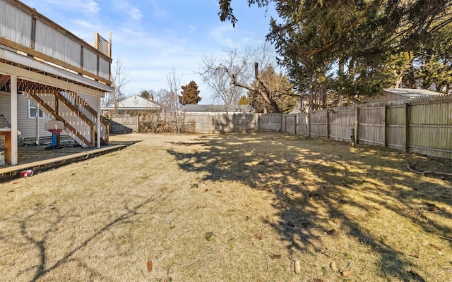 view of yard with a fenced backyard and stairs