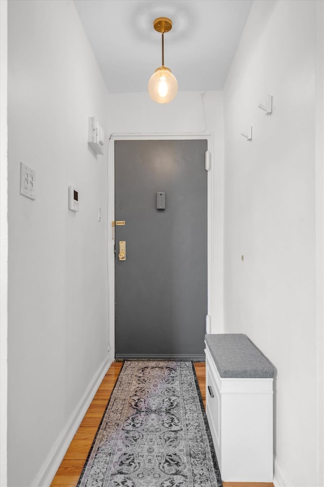 doorway with wood finished floors and baseboards