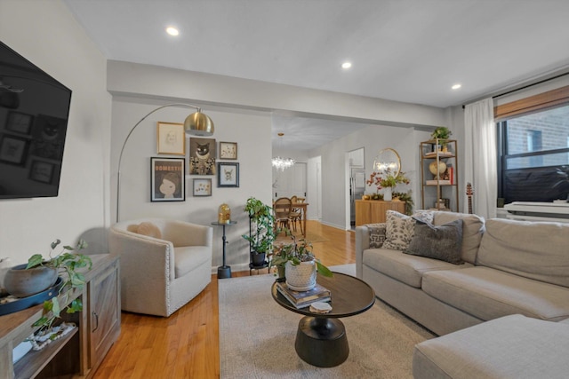 living room with light wood-style flooring, a chandelier, and recessed lighting