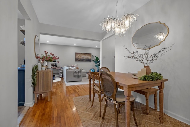 dining room with a chandelier, recessed lighting, wood finished floors, and baseboards