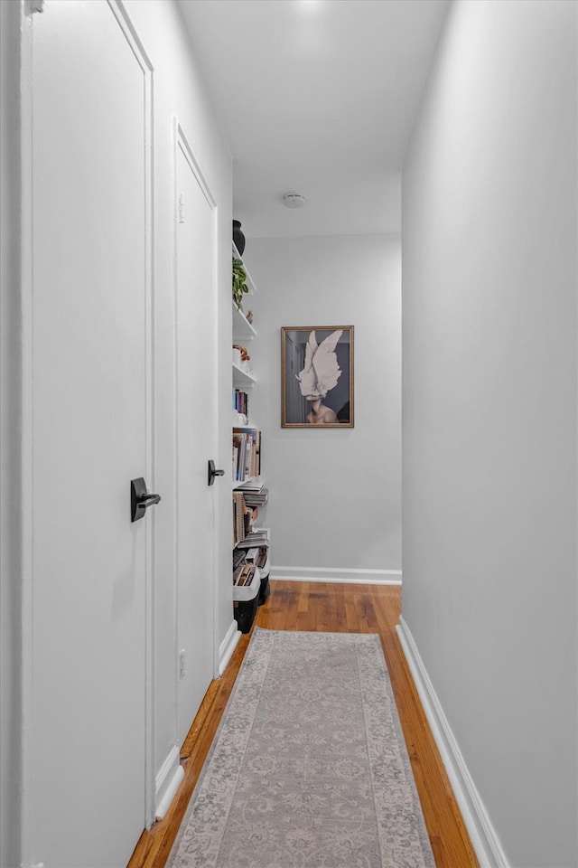 hallway with light wood-style floors and baseboards