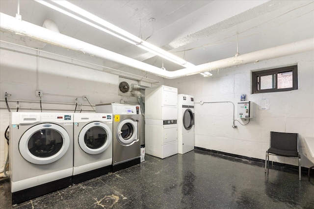 community laundry room featuring stacked washing maching and dryer and washing machine and clothes dryer