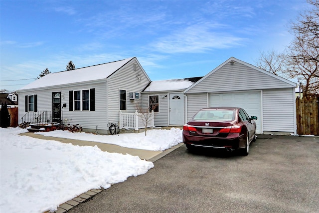 ranch-style home featuring an attached garage and aphalt driveway